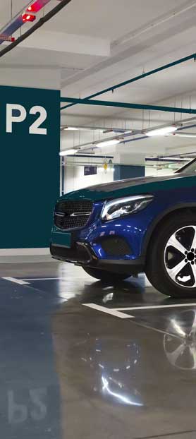 Une voiture bleue garée dans un parking officiel Paris Aéroport